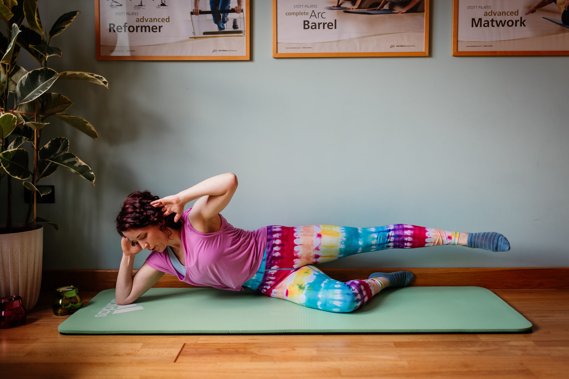 Emmeline demonstrates a side lying Wall Pilates exercise for the wall Pilates Beginners